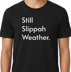 Black t-shirt with 'Still Slippah Weather' text worn by a person
