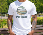 Person wearing a white t-shirt with a graphic design and text 'Pau Hana' outdoors.